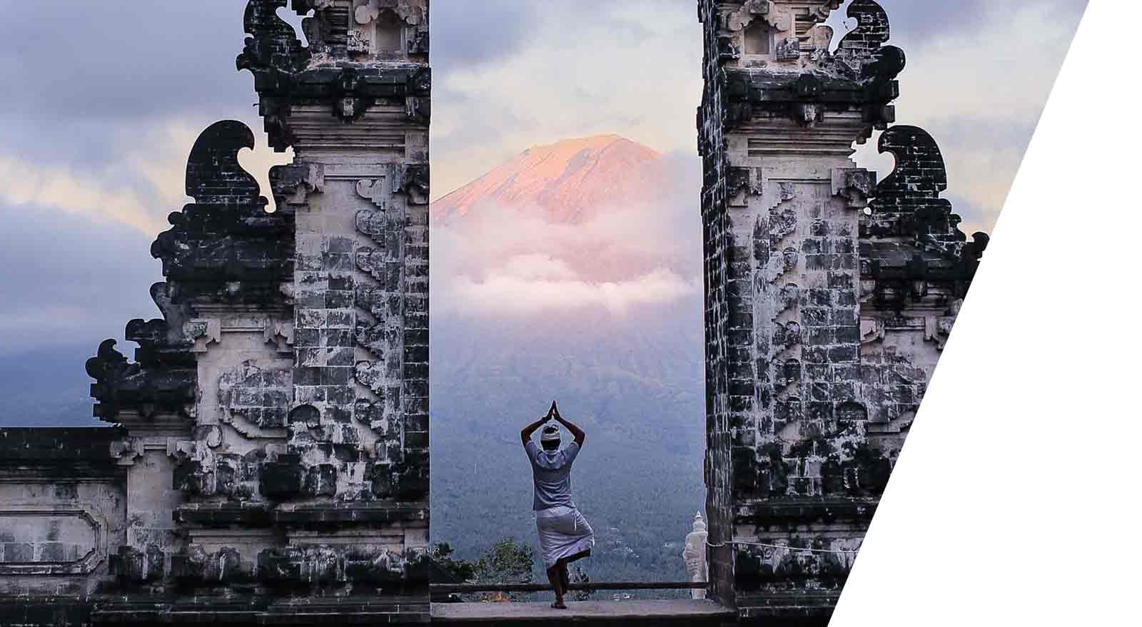 Student standing at the temple with view to the volcano