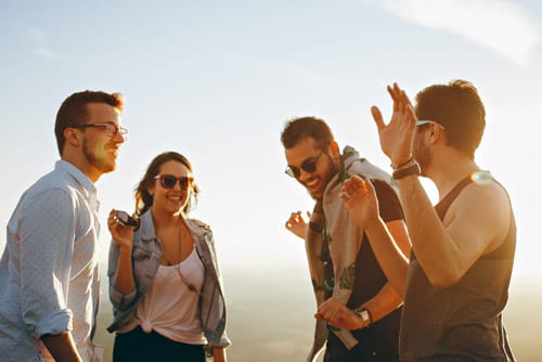 four people laughing and having fun outside